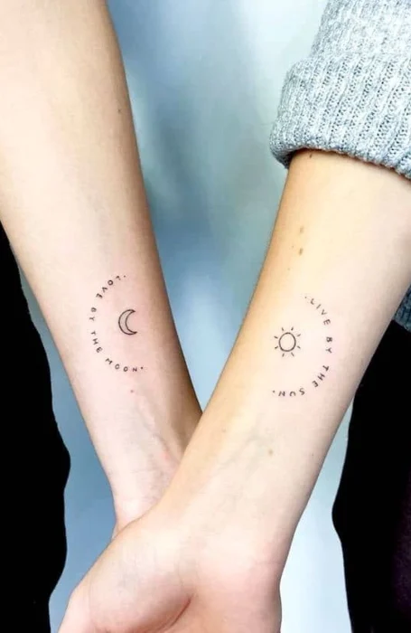 Minimalist matching sun and moon tattoos with text on forearms