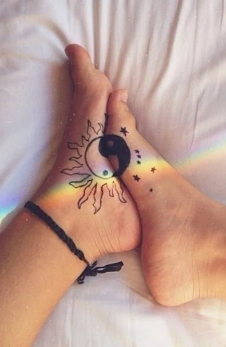 Yin-yang sun and moon tattoos with stars on feet