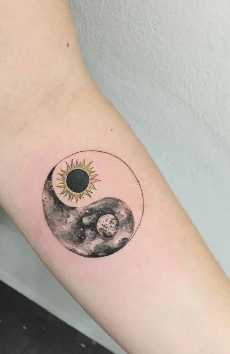 Yin-yang tattoo with sun and moon symbols in cosmic design