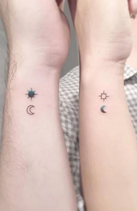 Small matching sun and crescent moon tattoos on the wrists of two individuals