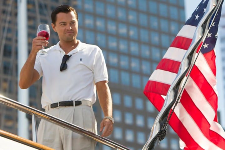 Leonardo DiCaprio standing near an American flag in The Wolf of Wall Street.