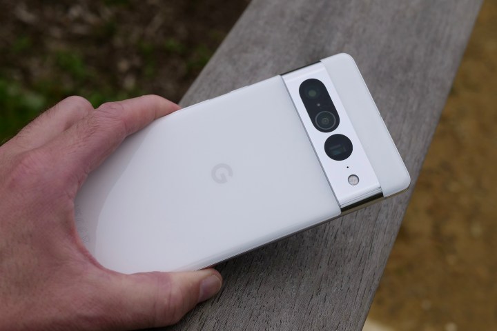 A man holding a Google Pixel 7 Pro, showing the back of the phone.