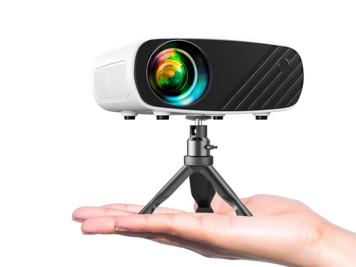 A hand holding the Elephas Mini Projector for a smartphone mounted on a tripod.