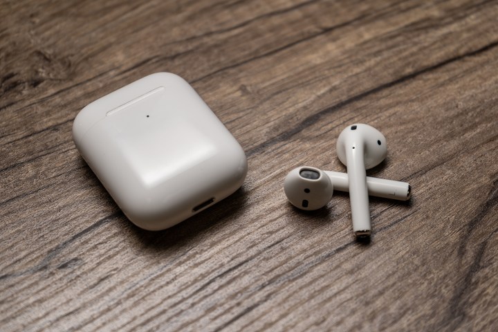 The second generation Apple AirPods next to their charging case.