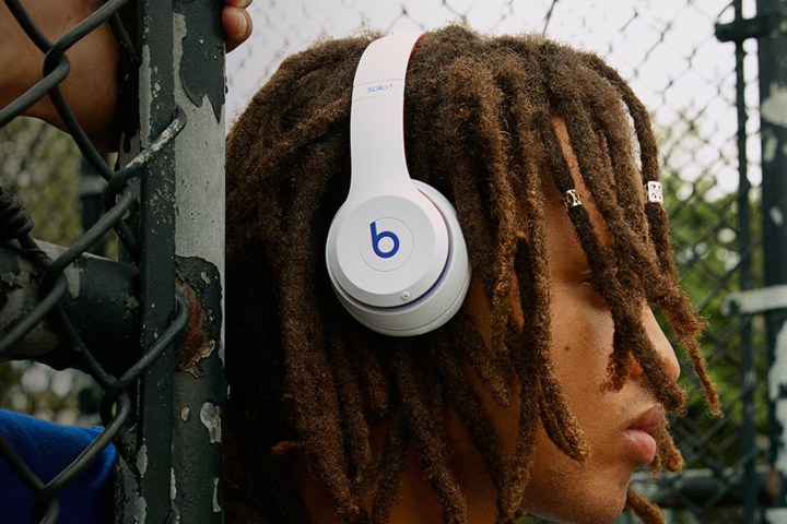 A woman wearing Beats Solo3 wireless headphones in white.