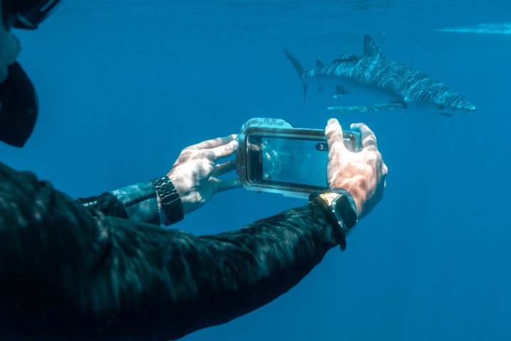 A person using Oceanic+ dive housing.