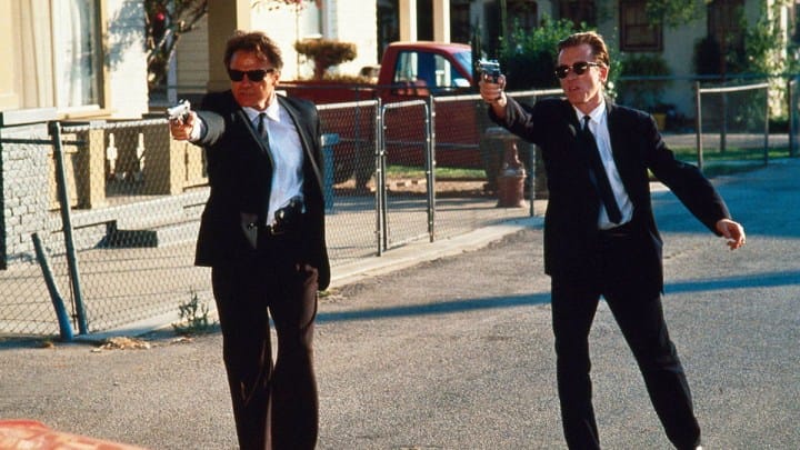 Harvey Keitel and Tim Roth as Mr. White and Mr. Orange in the film Reservoir Dogs pointing guns in the same direction.