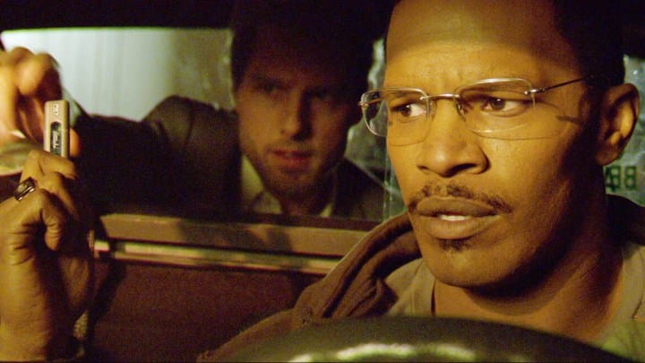 Tom Cruise sits in the back of a taxi and Jamie Foxx is driving in Collateral.