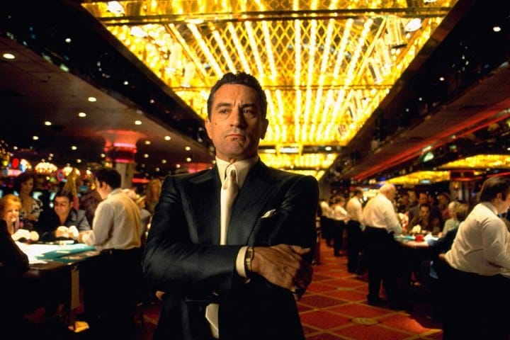 Robert De Niro stands under the casino lights at the casino.