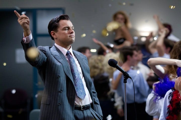 Leonardo DiCaprio standing near a microphone in The Wolf of Wall Street.