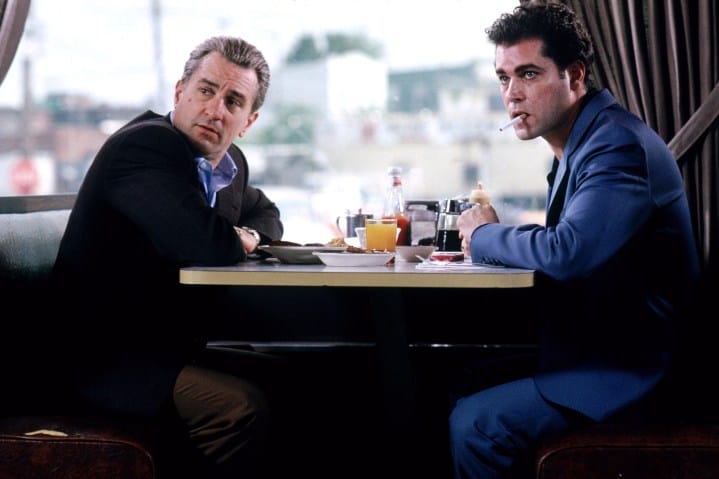 Robert De Niro and Ray Liotta sit together at a diner booth in Goodfellas.