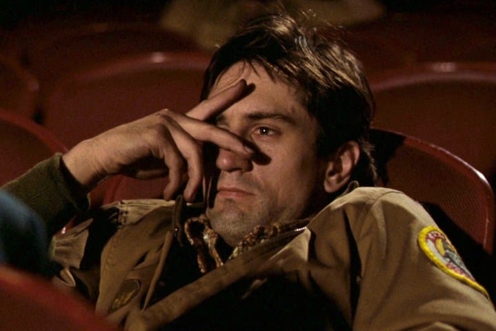 Robert De Niro sitting in a movie theater in Taxi Driver.