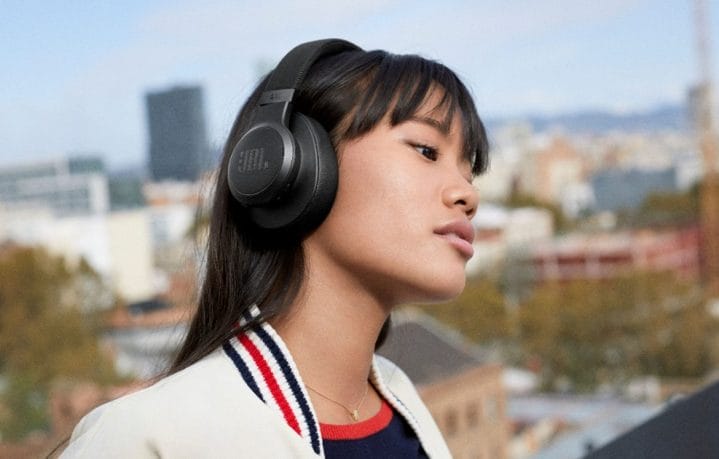 A woman wearing JBL Live 660NC wireless headphones while outside.