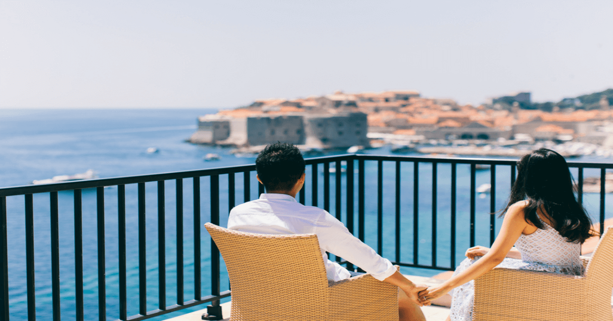 A couple sitting on a balcony with sea view OG SS16062017