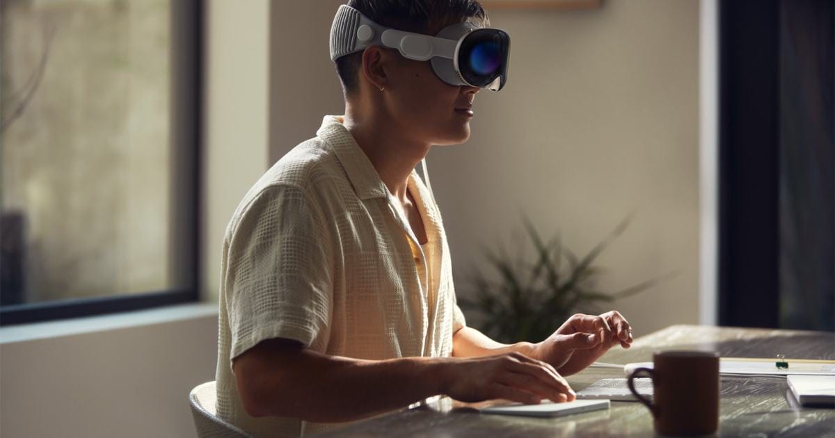 Apple Vision Pro being worn by a person while using a keyboard