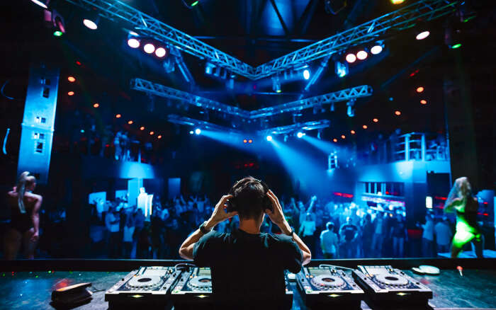 A DJ playing music for the audience at a club on a DJ Night