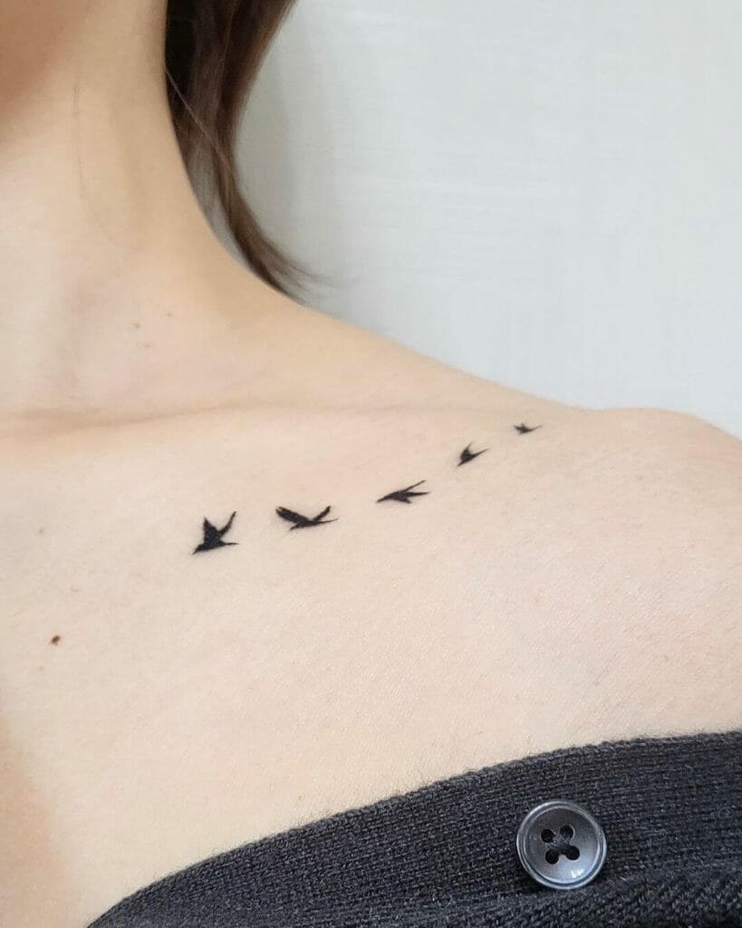 Tattoo of a flock of flying birds on the collarbone