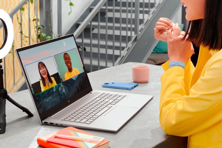 A woman video chats with her friends on an HP Envy laptop.