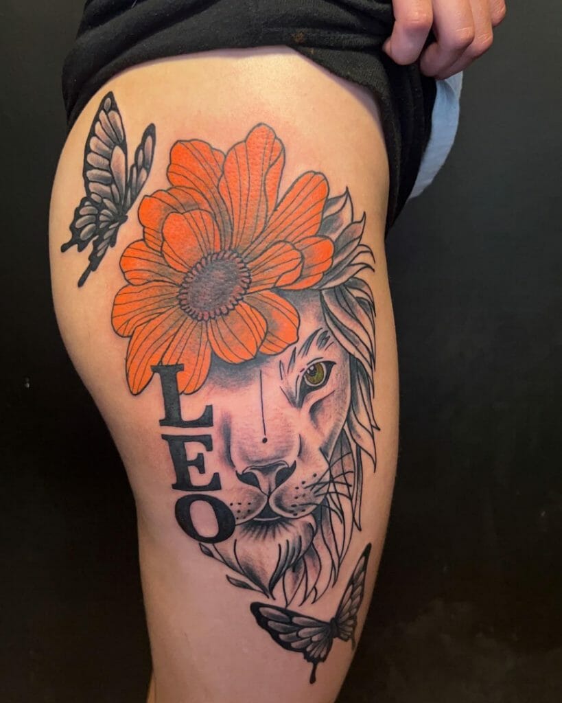 A detailed lion tattoo on the thigh featuring an orange flower and butterflies, with the word "LEO" integrated into the design.