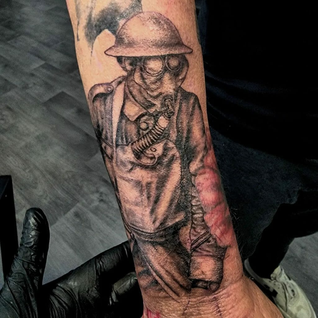 Forearm tattoo of a WWI soldier wearing a gas mask and helmet, depicted in black and grey with realistic wartime imagery