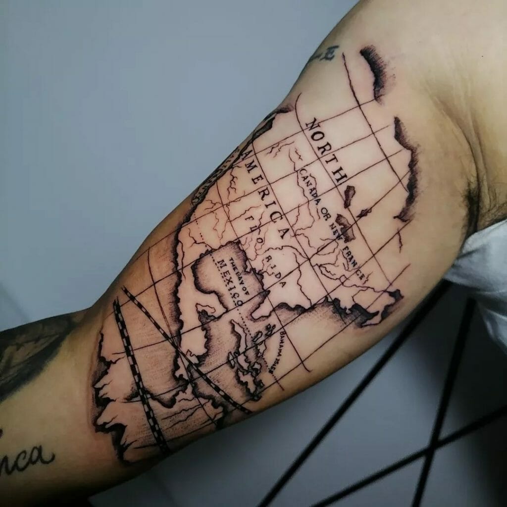 Detailed linework tattoo of a vintage-style map of North America on the upper arm, featuring geographical boundaries and coordinates