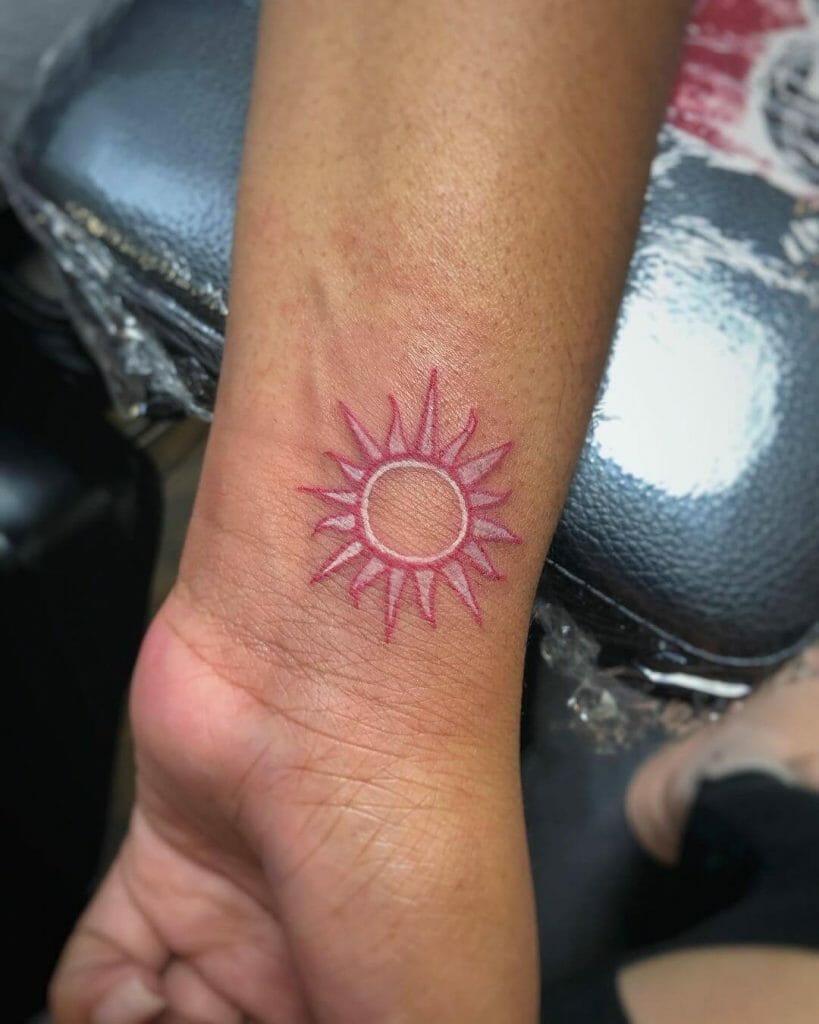 Idea de tatuaje de sol rosa en la muñeca