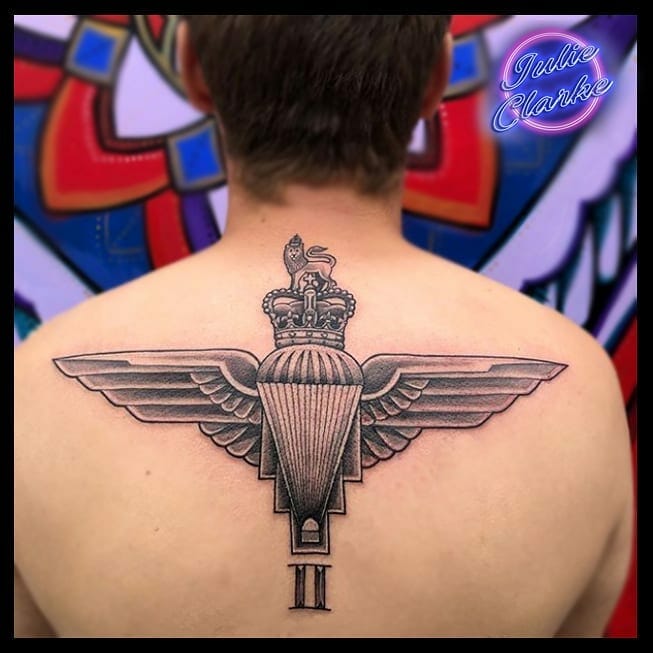 Parachute Regiment wings tattoo on the upper back, featuring a crown, parachute, and Roman numeral II in black and grey ink