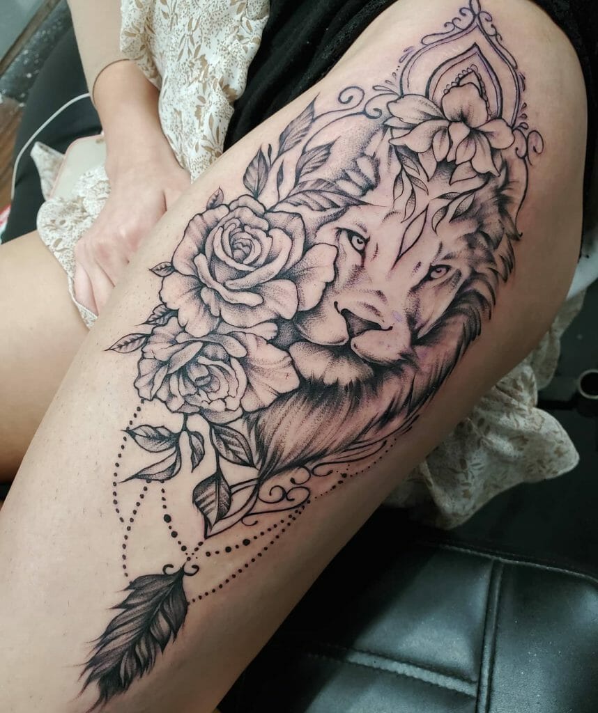 Thigh tattoo of a lion's face surrounded by roses and ornamental designs, featuring intricate line work and dot detailing.