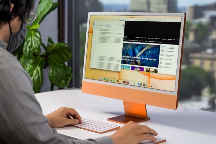 The man is using a 24-inch M1 iMac.