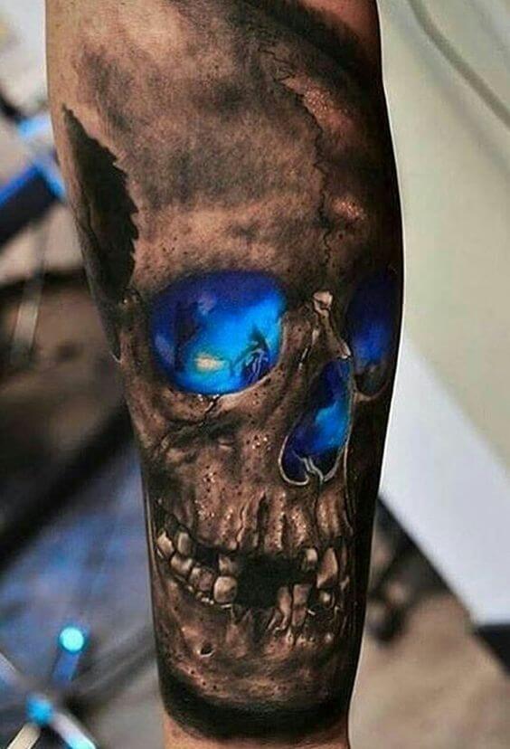 Realistic blue glowing skull tattoo on forearm with intricate shading and vibrant colors