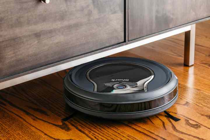 Shark ION robot vacuum working under credenza.