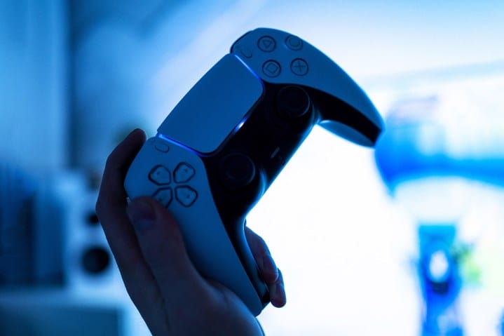 A person holds a PS5 controller.