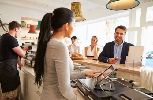 man at cafe ordering from woman at counter