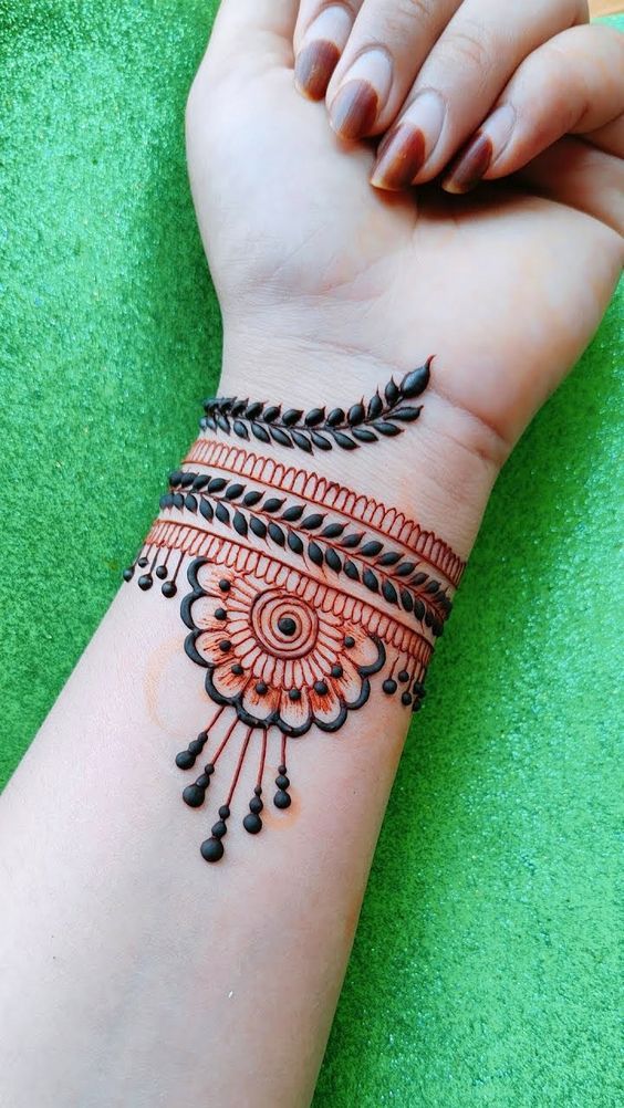 Wrist band Mehndi design with intricate leaf patterns and a circular floral motif, ideal for casual and modern events