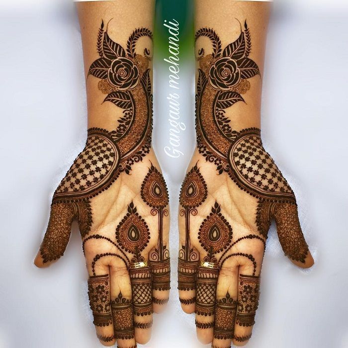 Symmetrical peacock and floral Mehndi design covering both palms with intricate patterns, perfect for bridal and festive occasions