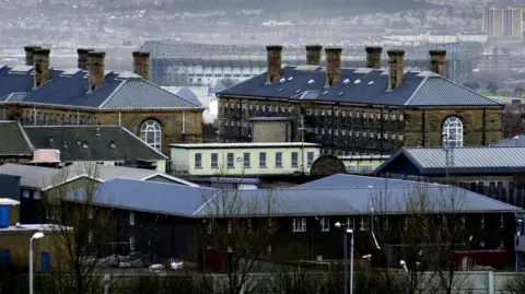 PA Media A view of Barlinnie prison showing the roofs of several buildings, with housing further away in the background