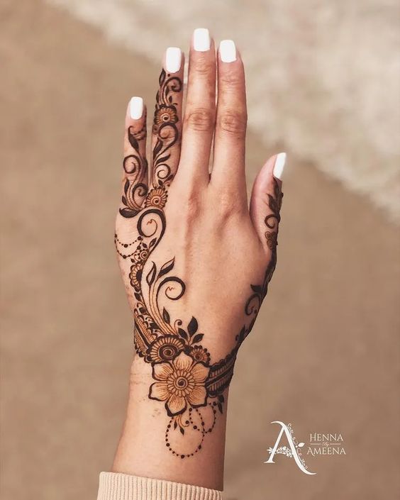 Floral Mehndi design on the back of the hand with swirling vines and intricate detailing, perfect for modern brides and festive occasions