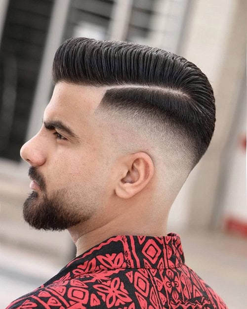 Man with a slicked-back crew cut hairstyle featuring a sharp fade and side part, wearing a red patterned shirt