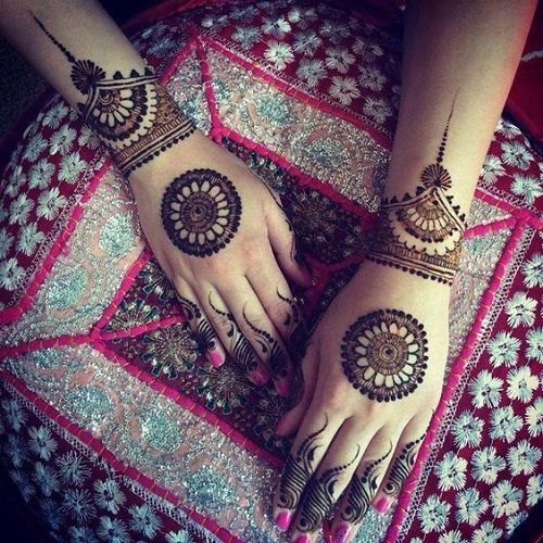 Traditional Mehndi design with large mandala patterns on the back of both hands, adorned with dotted wristbands and fingertip detailing