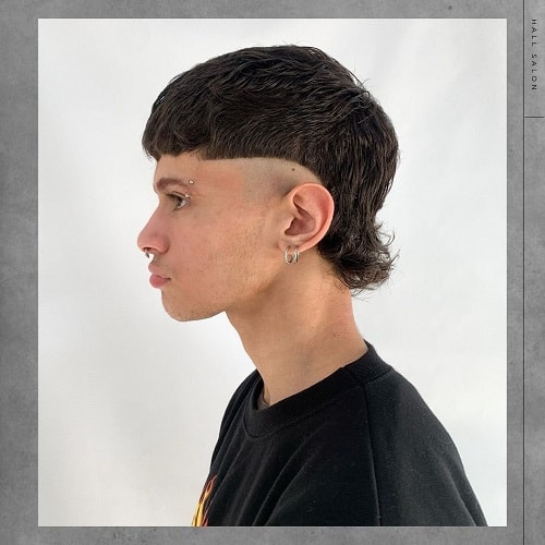 Side view of a man with a buzzed mullet and bowl cut, featuring a sharp fade and short mullet tail