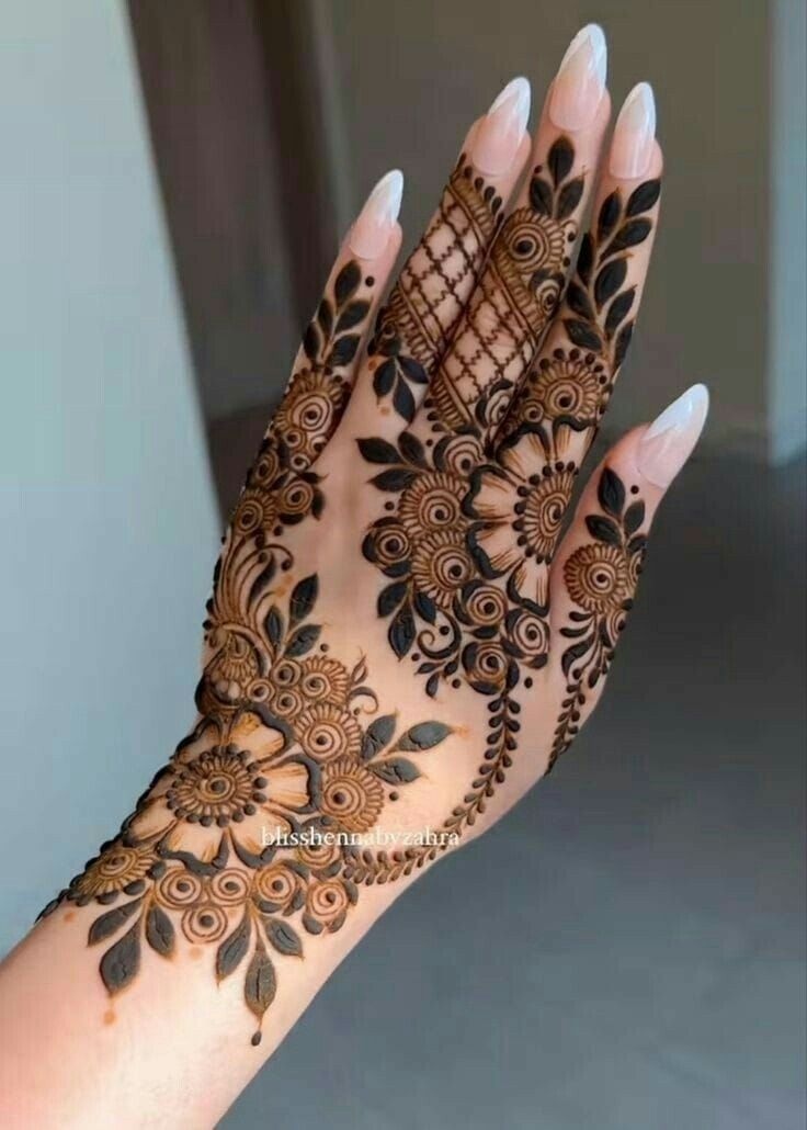 Floral and leafy Mehndi design with intricate detailing on the back of the hand and fingers, perfect for weddings and special occasions