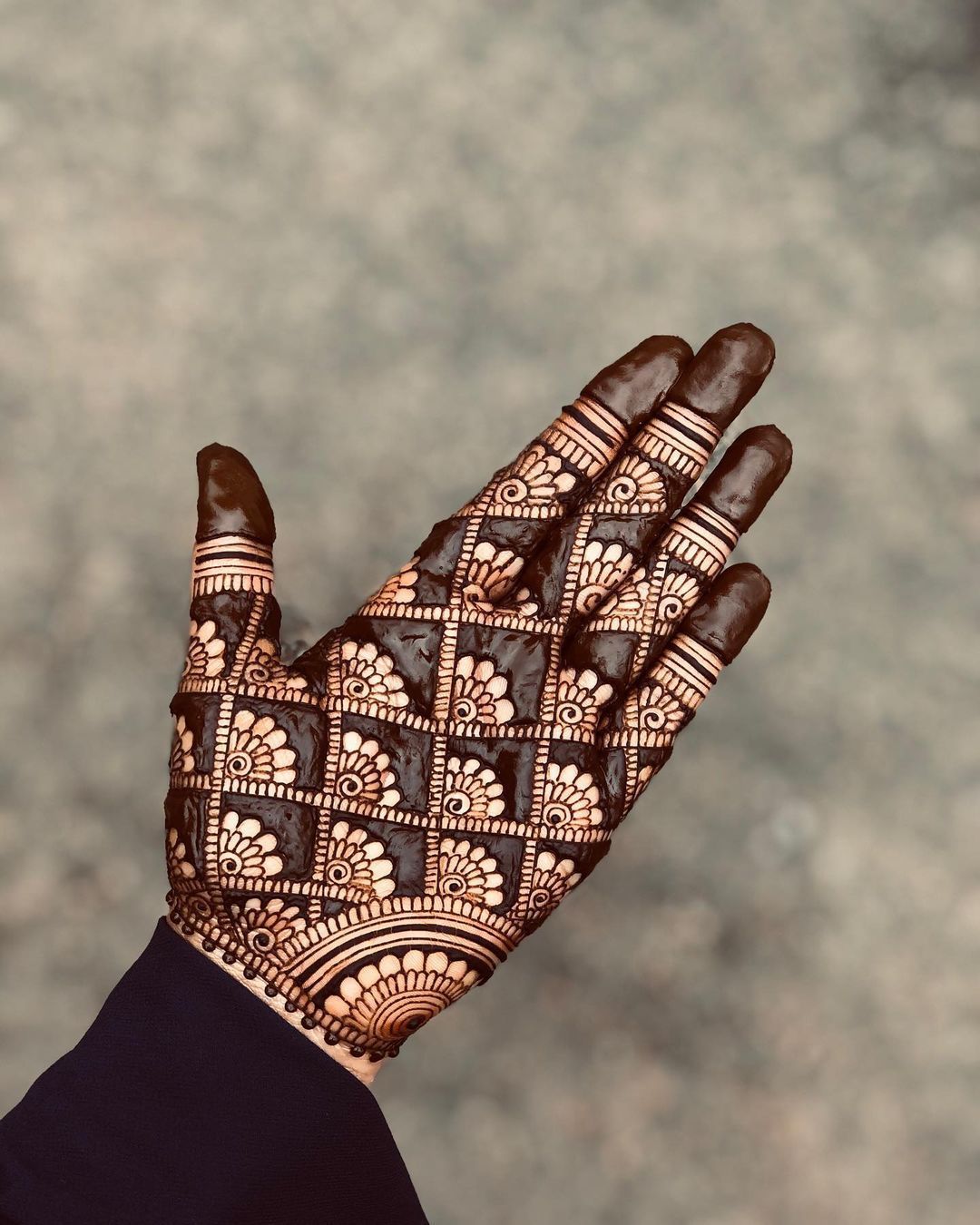 Geometric grid Mehndi design on the palm with intricate floral accents and bold detailing, perfect for modern bridal looks