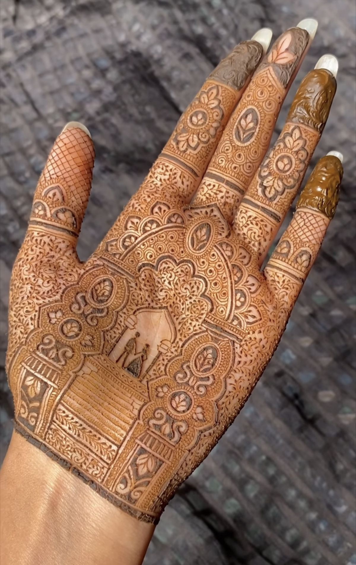 Intricate Arabic Mehndi design with detailed floral, geometric motifs and bride-groom illustration on the palm