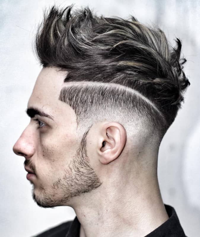 Side profile of a man with a high drop fade haircut, textured spiky top, and a defined hard part.