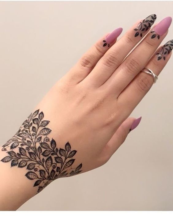 Simple and elegant Mehndi design featuring a leafy pattern on the wrist extending towards the back of the hand, with small leaf motifs on the fingertips