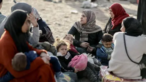 AFP Displaced Palestinians fleeing Beit Lahia in the northern Gaza Strip, rest on Salah al-Din street (17 November 2024)