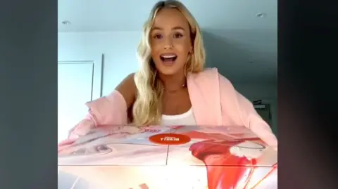 Cissy Jones/TikTok Cissy Jones holding a pink and red box in one of her beauty advent calendar TikTok videos