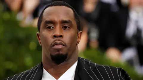 Reuters Sean "Diddy" Combs in a pinstripe suit at the Met Gala, before his arrest on sex trafficking charges