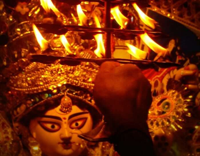 A man offering aarti to maa during Kolkata Durga Puja celebrations