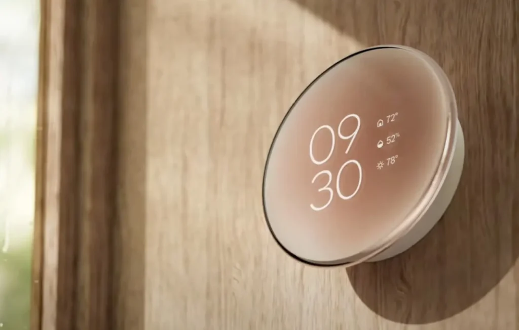 A Nest Learning Thermostat mounted on a wall, displaying the current temperature with a sleek, modern interface.